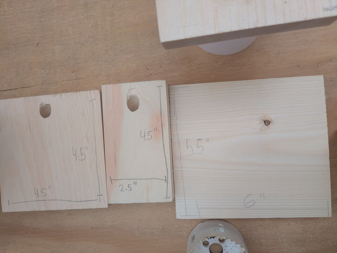 Three cut pine pieces laid side by side, each marked in pencil with its measurements.