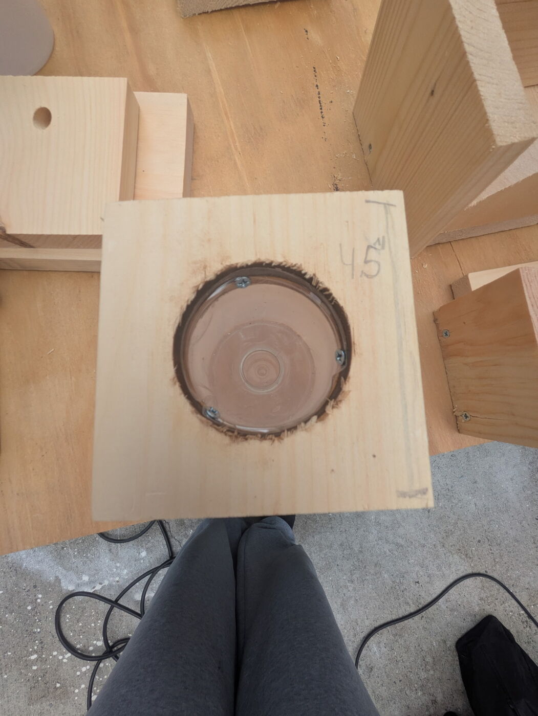 A pine base piece with a round funnel opening cut into it.
